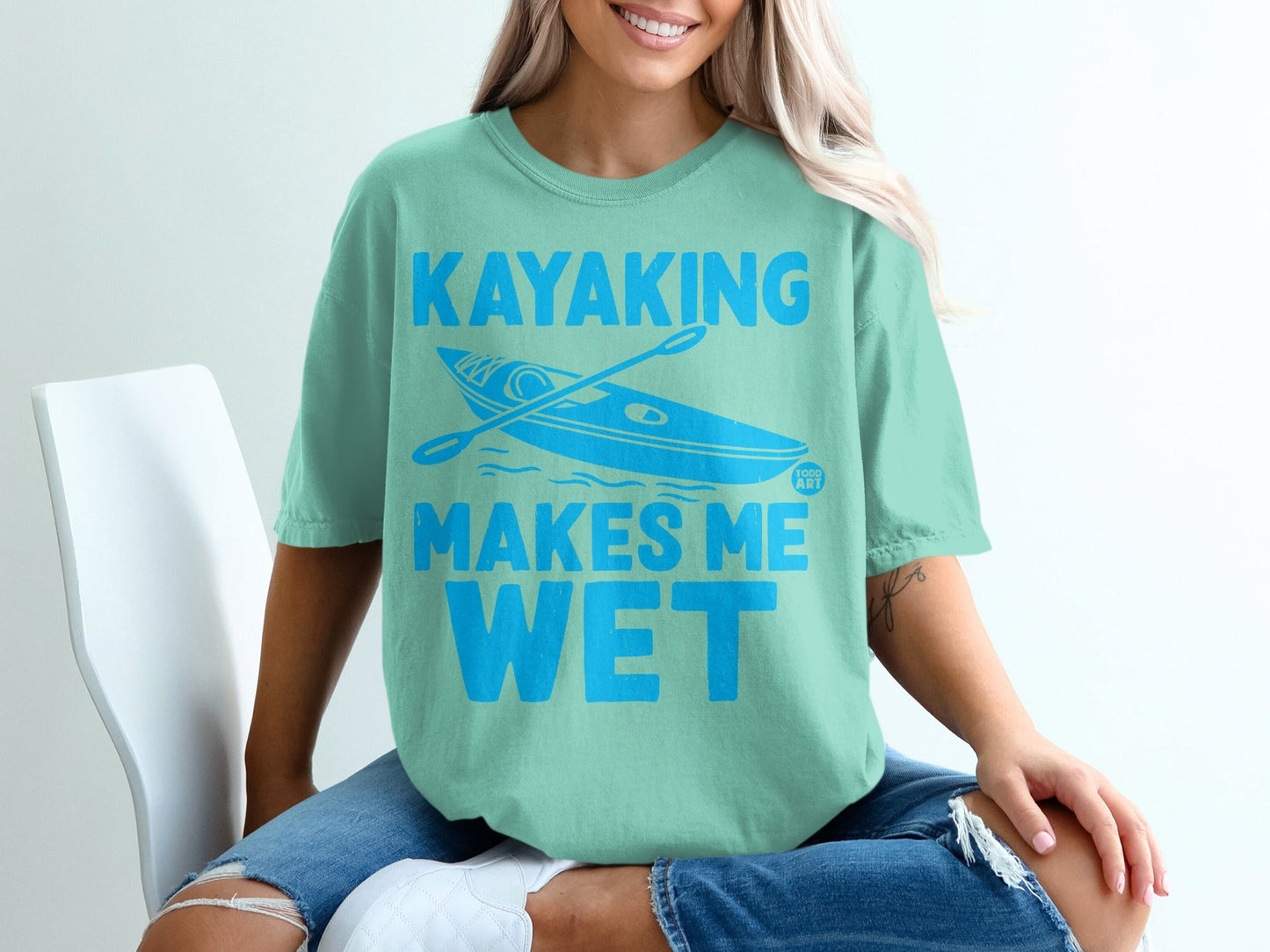 Teal t-shirt with "Kayaking Makes Me Wet" text and a kayak graphic.