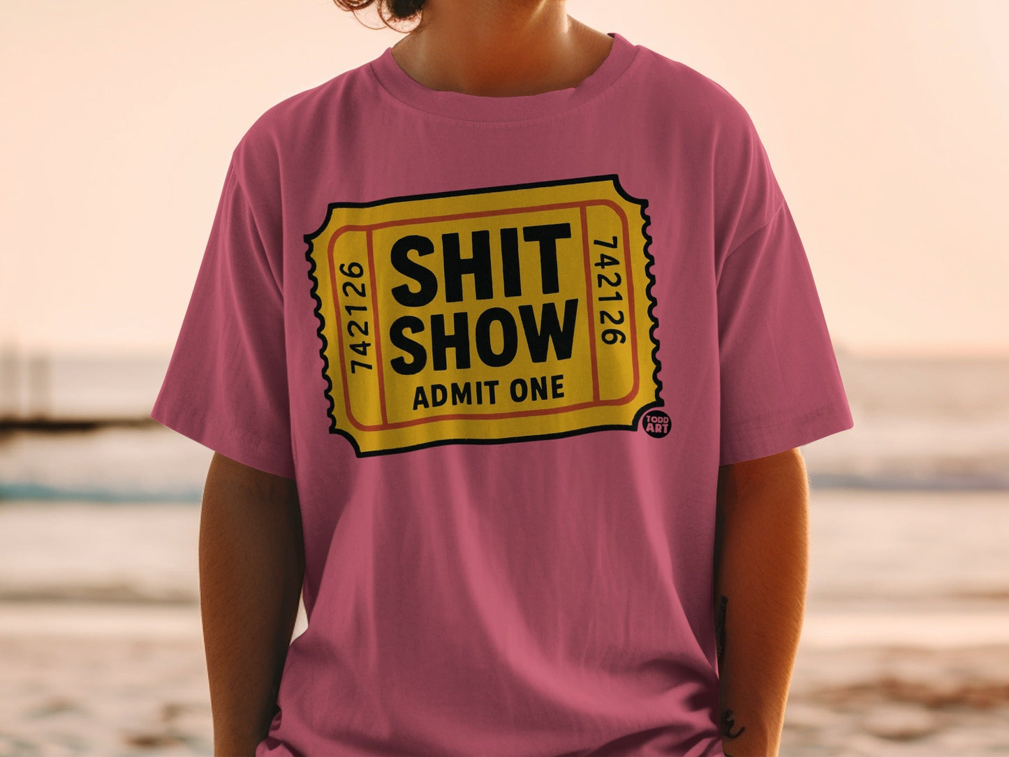 Pink t-shirt with "Shit Show Admit One" ticket design.