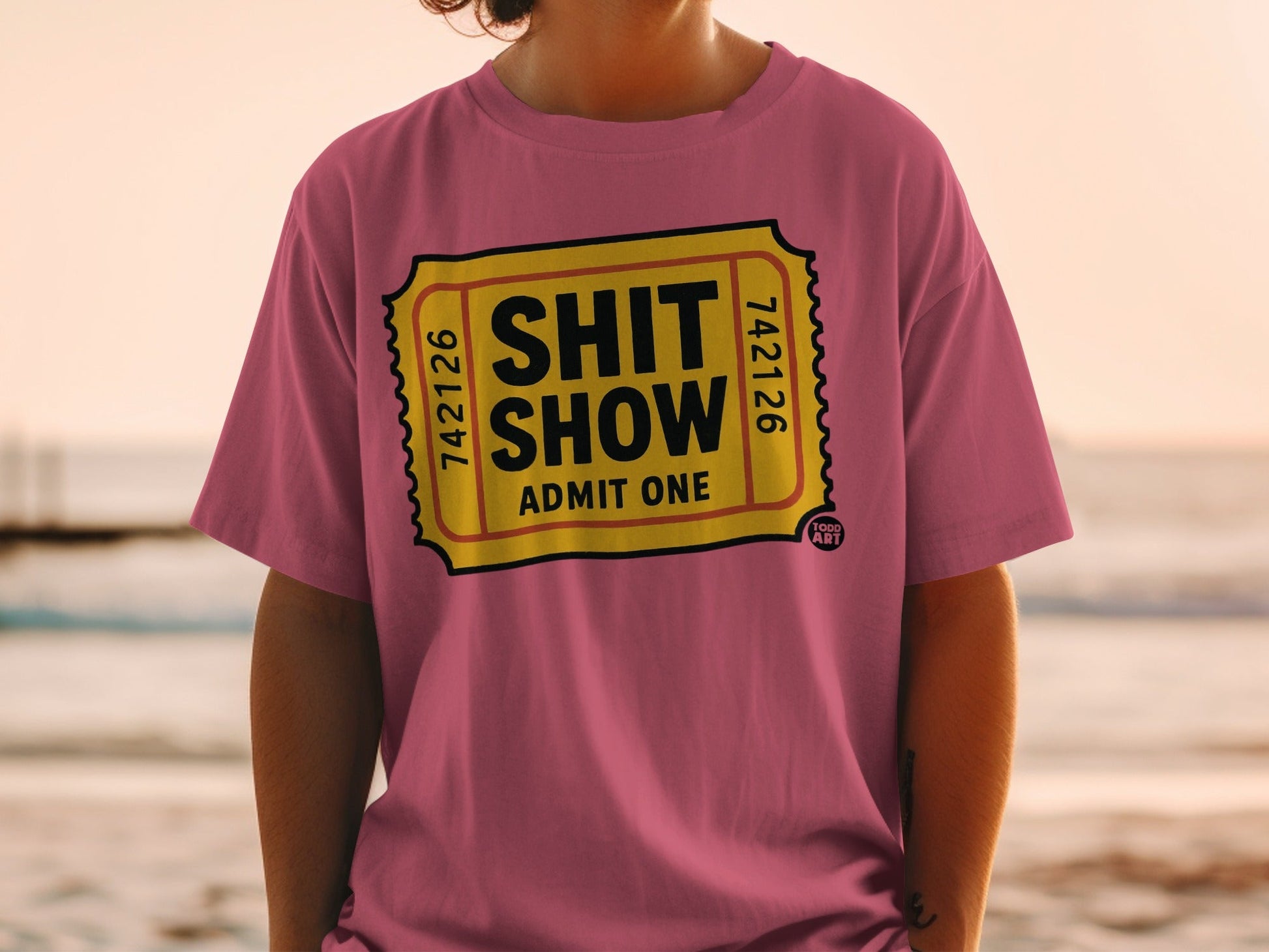 Pink t-shirt with "Shit Show Admit One" ticket design.