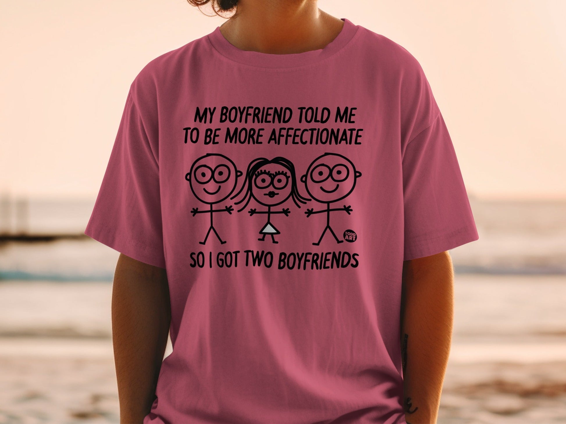 Pink t-shirt with text and cartoon couple figures.