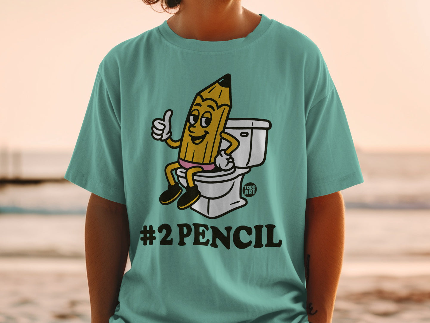Teal t-shirt with cartoon pencil giving thumbs up on toilet, "#2 PENCIL" text.