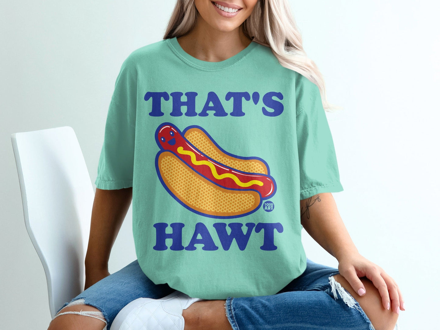 Teal t-shirt with "THAT'S HAWT" text and a cartoon hot dog graphic.
