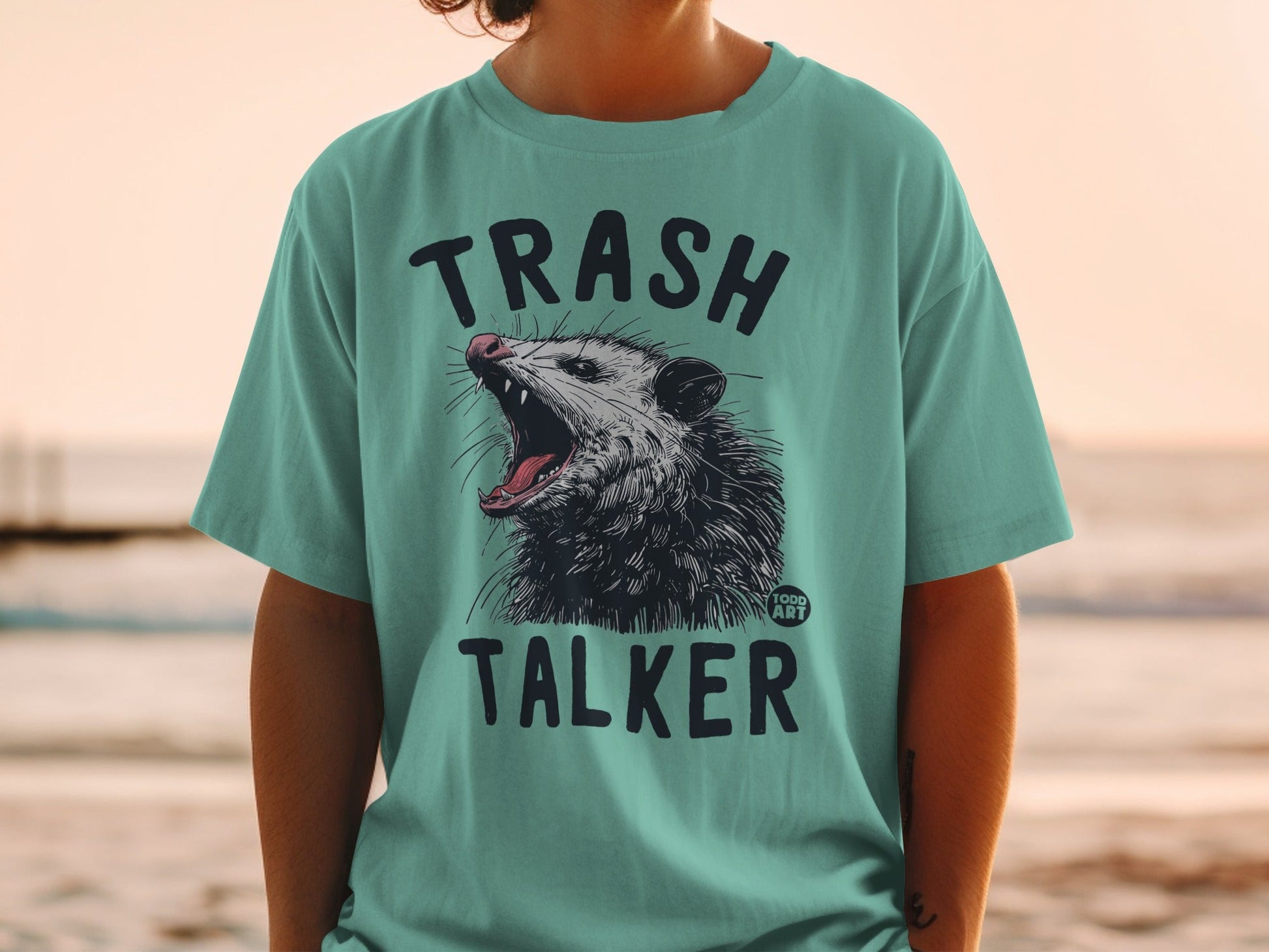 Teal t-shirt with "TRASH TALKER" text and a snarling opossum graphic.