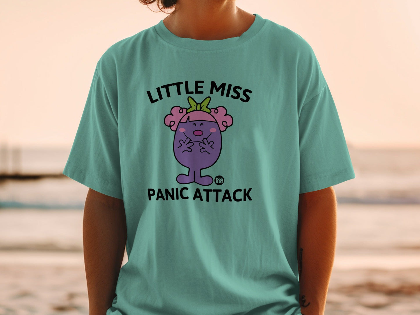 Teal t-shirt with "Little Miss Panic Attack" text and cartoon character.