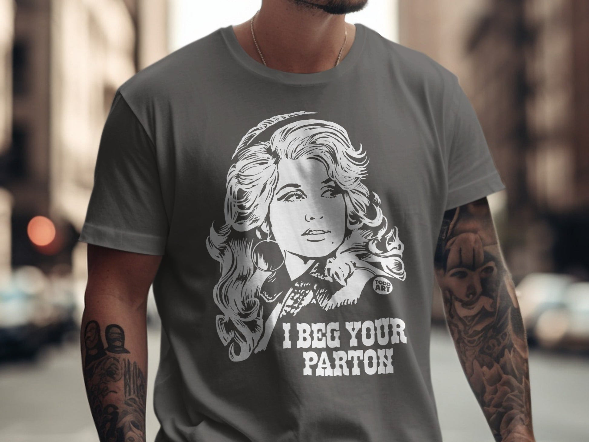 T-shirt with Dolly Parton graphic and text "I BEG YOUR PARTON".