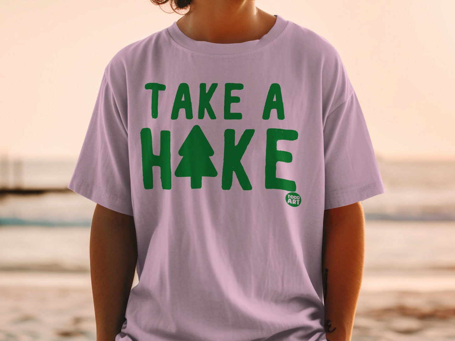 Pink t-shirt with green "TAKE A HIKE" text and a Christmas tree graphic.
