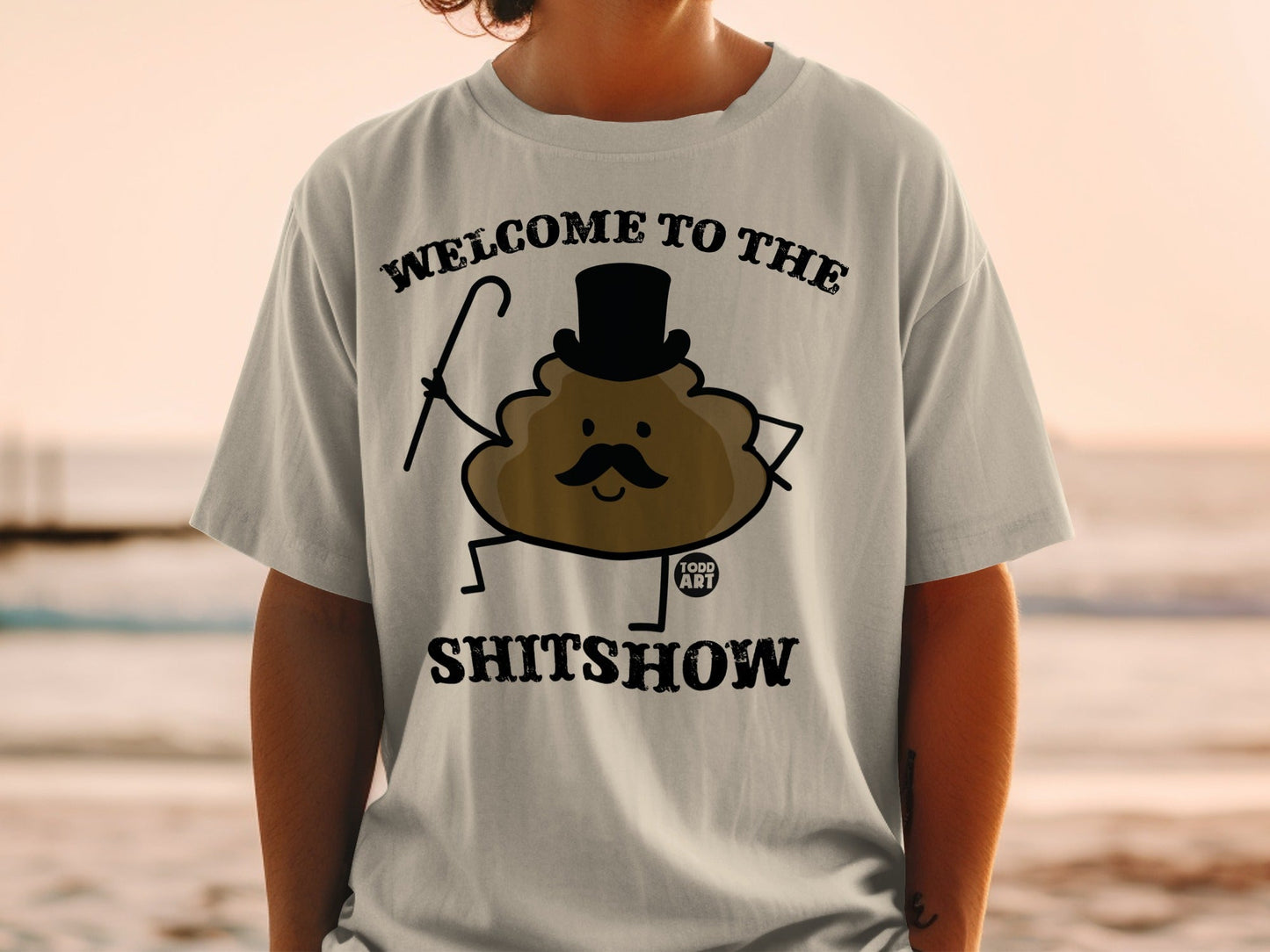 Shirt with cartoon poop wearing a top hat and cane, text reads "WELCOME TO THE SHITSHOW".