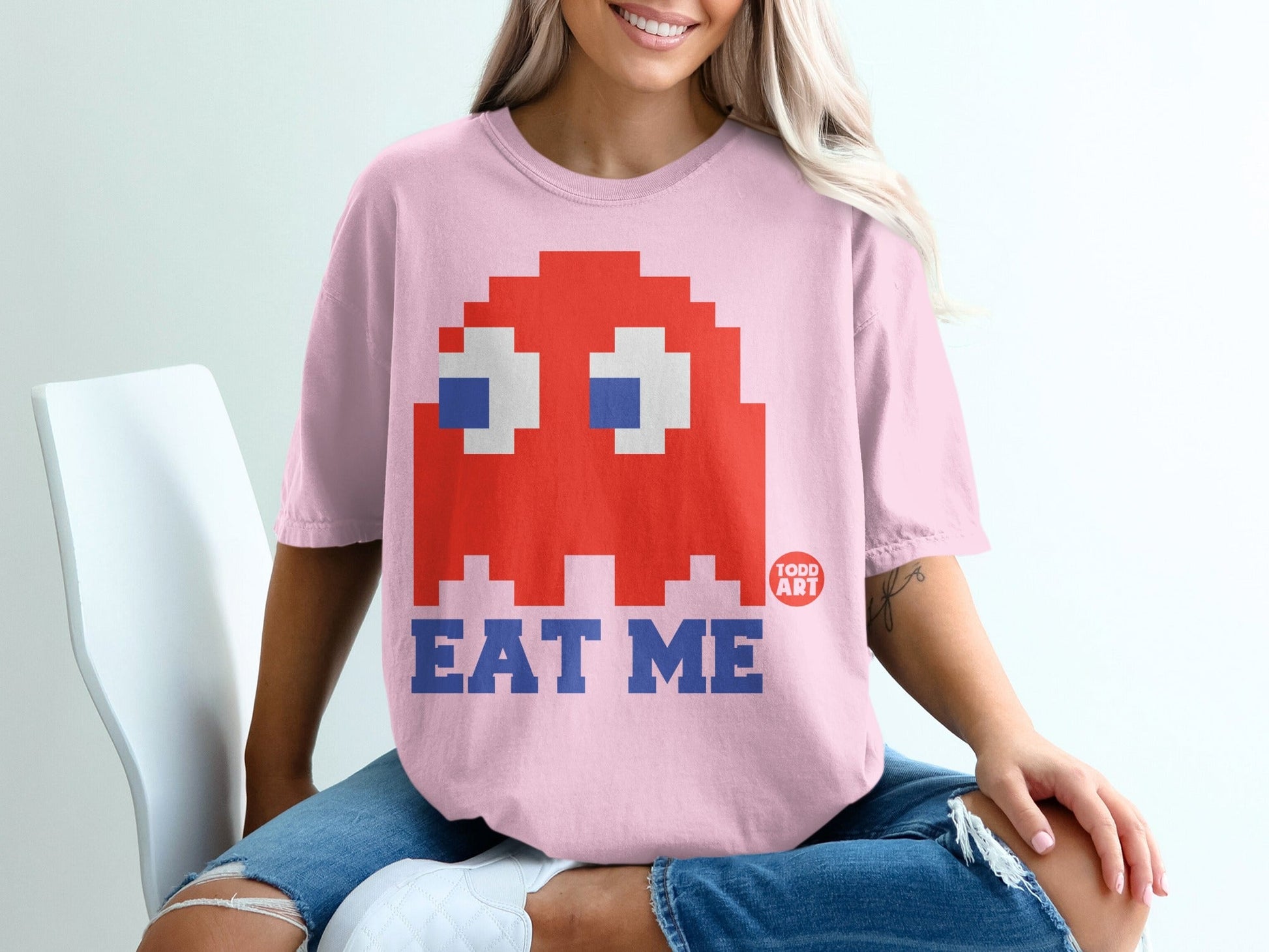 Pink t-shirt with Pac-Man ghost graphic and "EAT ME" text.