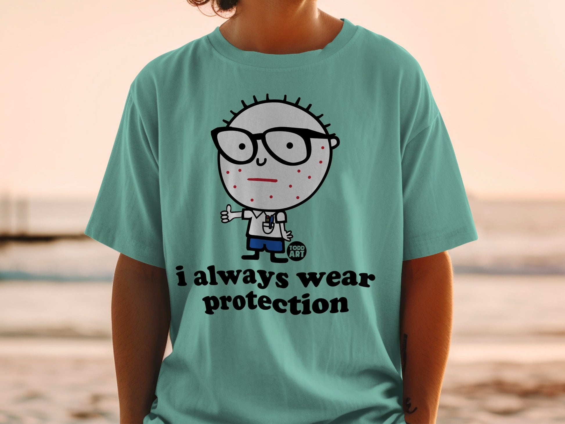 Teal t-shirt featuring cartoon character with glasses and "i always wear protection" text.
