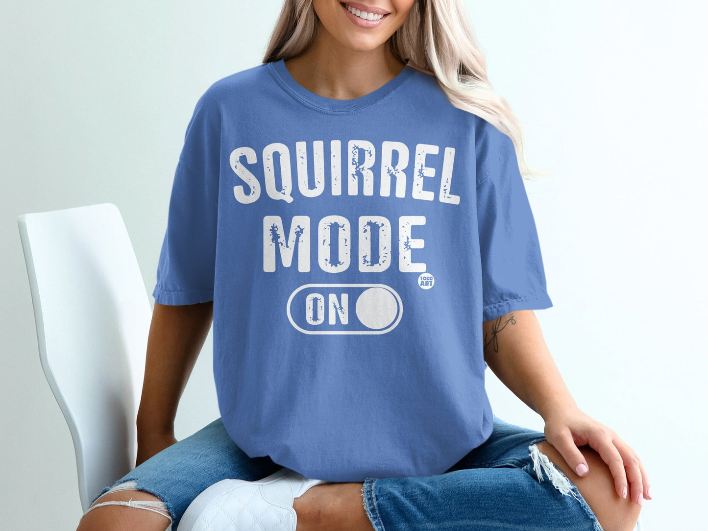 Blue t-shirt with "SQUIRREL MODE ON" and a small circular logo.