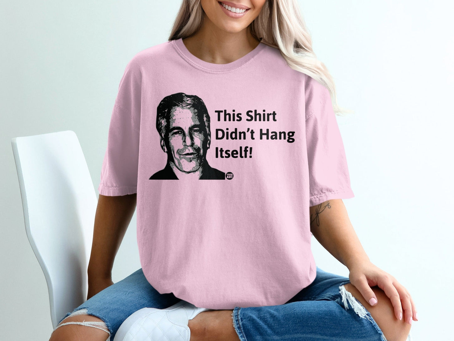 Pink t-shirt with a portrait and the text "This Shirt Didn't Hang Itself!".