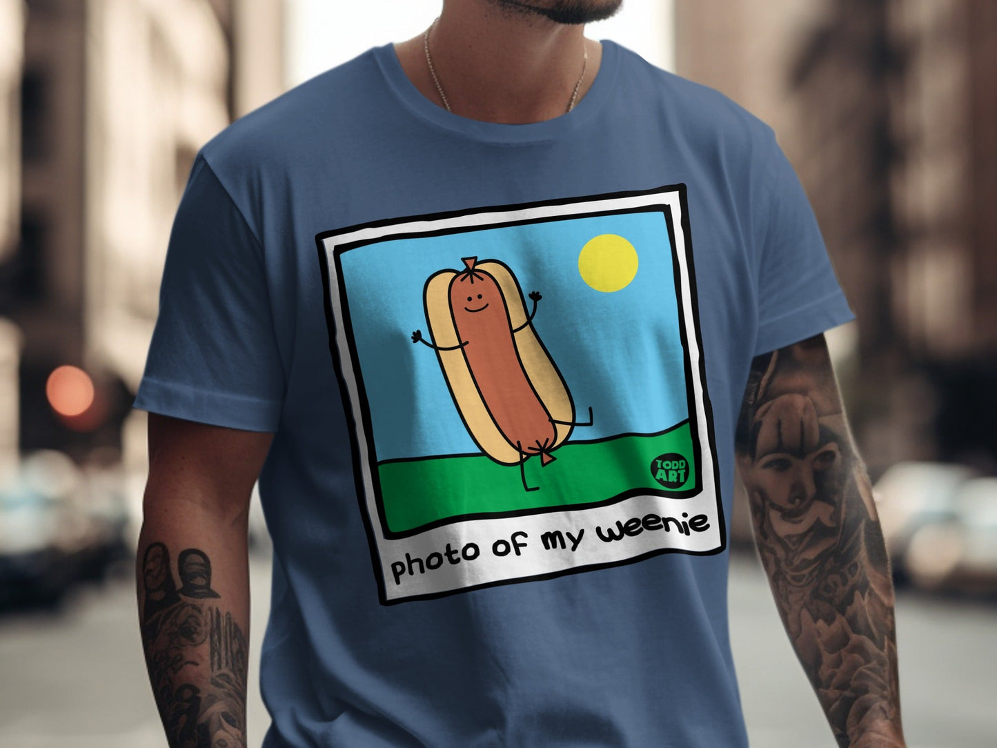 Cartoon hot dog with arms and legs in a photo frame, text "photo of my weenie".