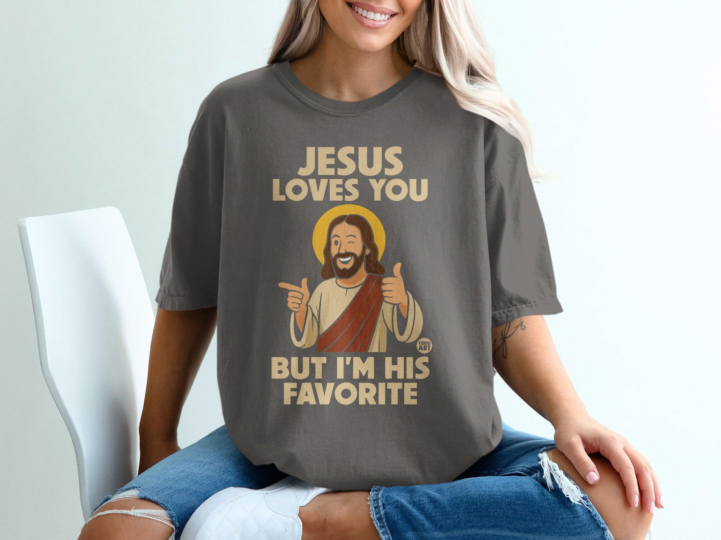 Dark gray t-shirt with "JESUS LOVES YOU BUT I'M HIS FAVORITE" and cartoon Jesus.