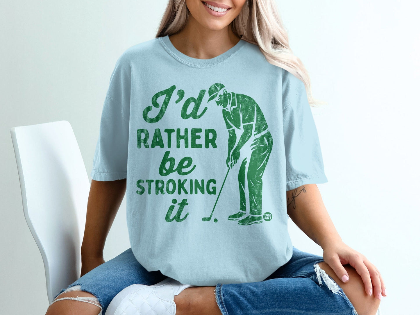 Light blue t-shirt with green text "I'd rather be stroking it" and a golfer.