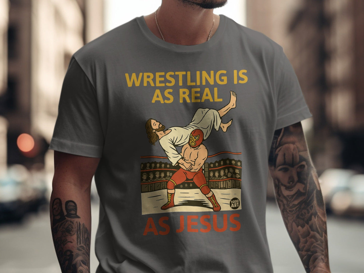 T-shirt graphic: Jesus wrestling, text "WRESTLING IS REAL AS JESUS".