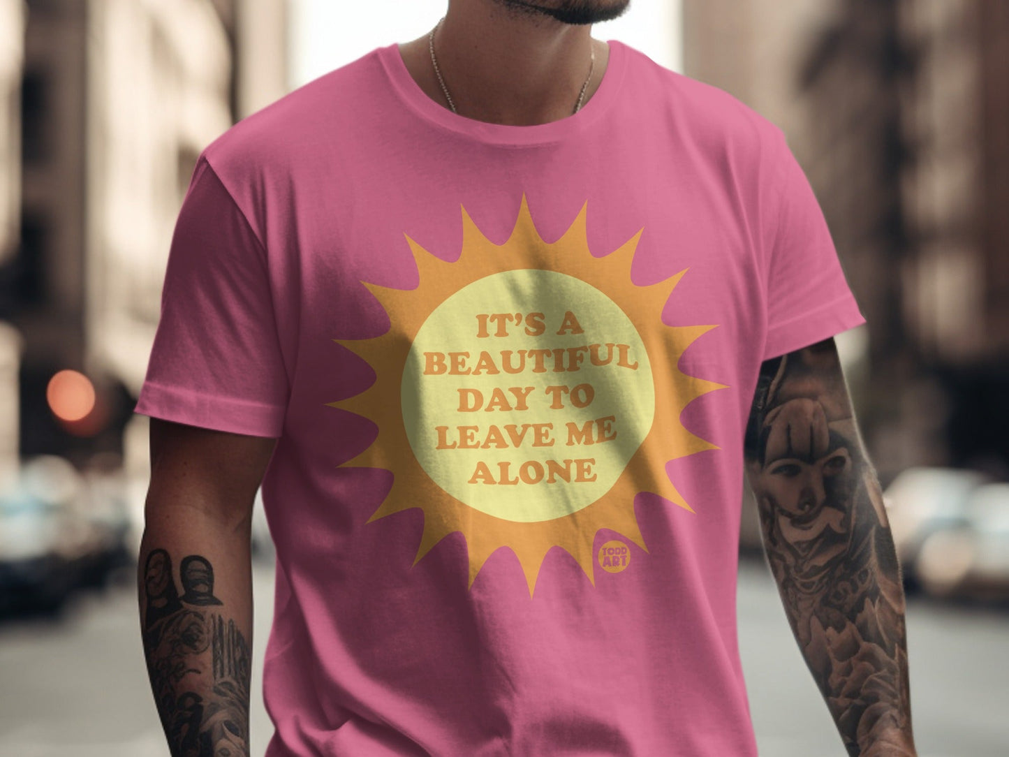Pink t-shirt with yellow sun graphic and "It's a beautiful day to leave me alone" text.