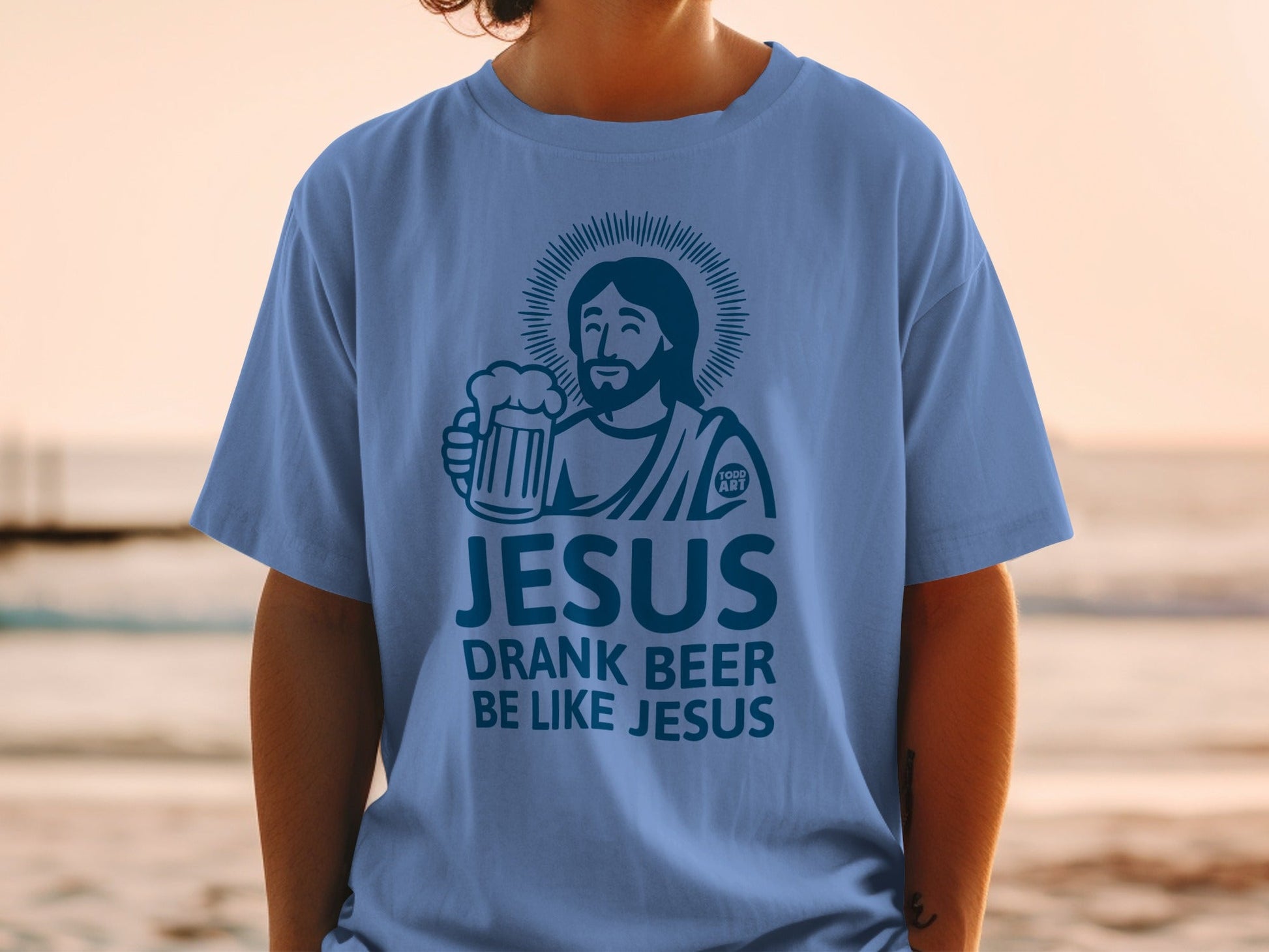 Light blue t-shirt with "Jesus Drank Beer Be Like Jesus" graphic and Jesus holding a beer.