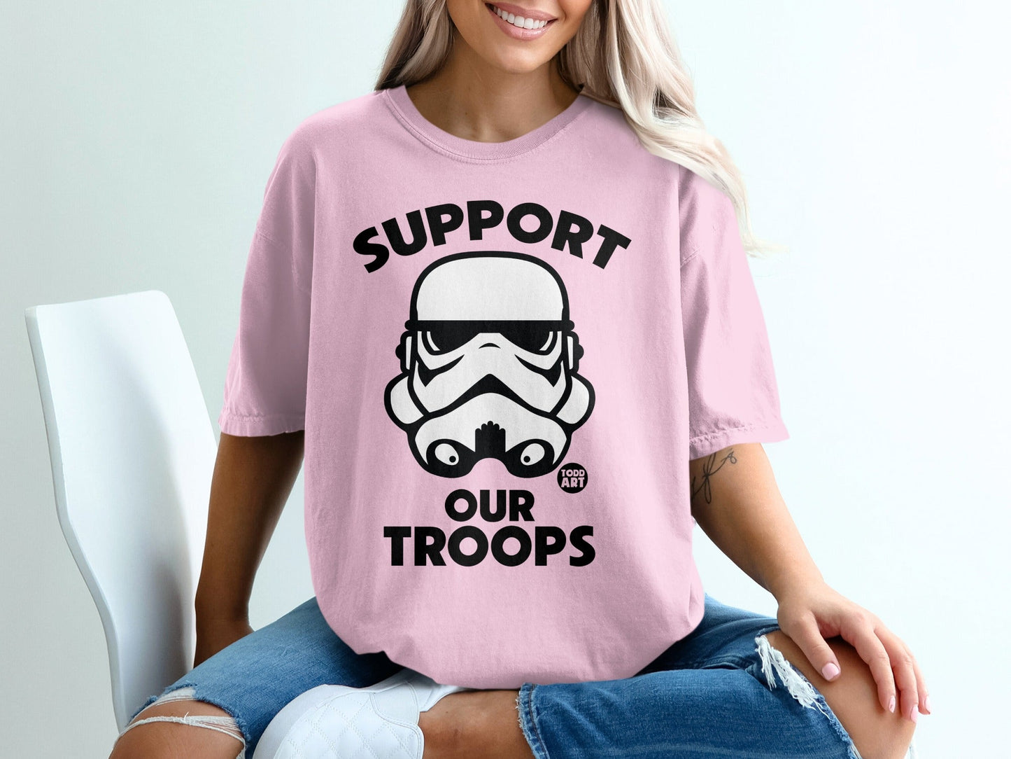 Pink t-shirt with black Stormtrooper helmet graphic and text "SUPPORT OUR TROOPS".
