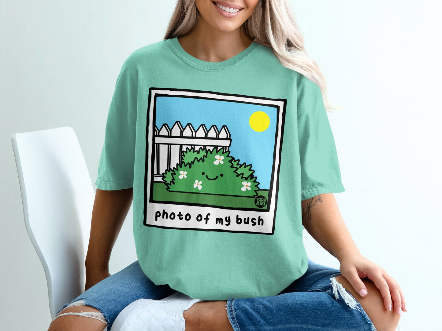 Green t-shirt with cartoon bush and text "photo of my bush."