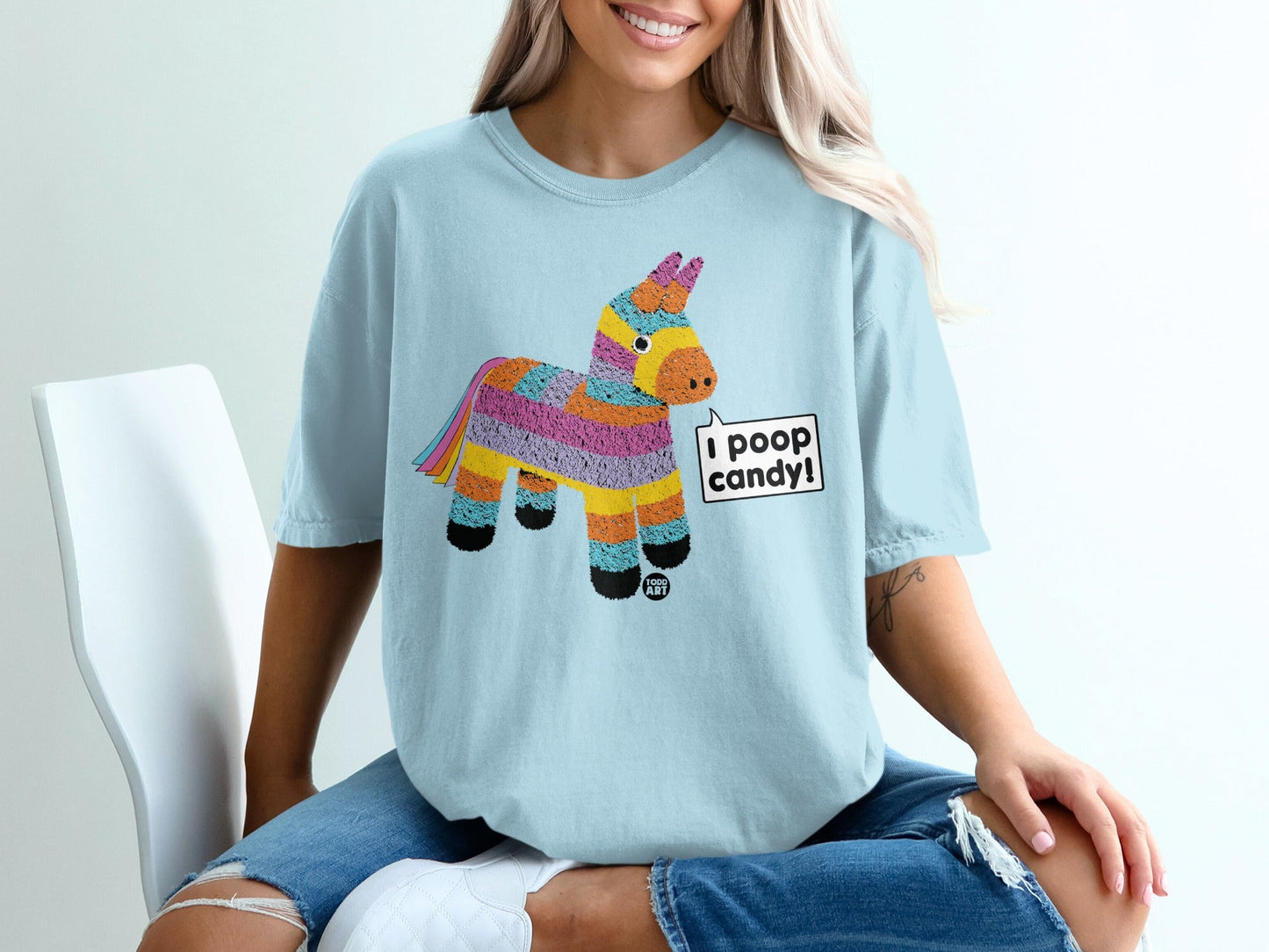 Light blue t-shirt with a colorful pi√±ata graphic that says "I poop candy!".