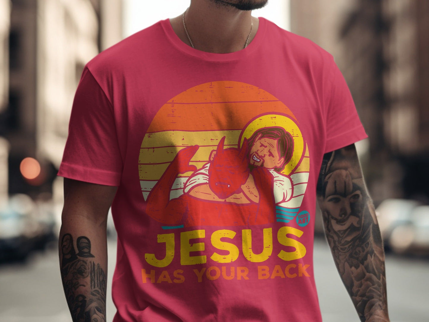 T-shirt with Jesus and devil graphic, "JESUS HAS YOUR BACK" text.