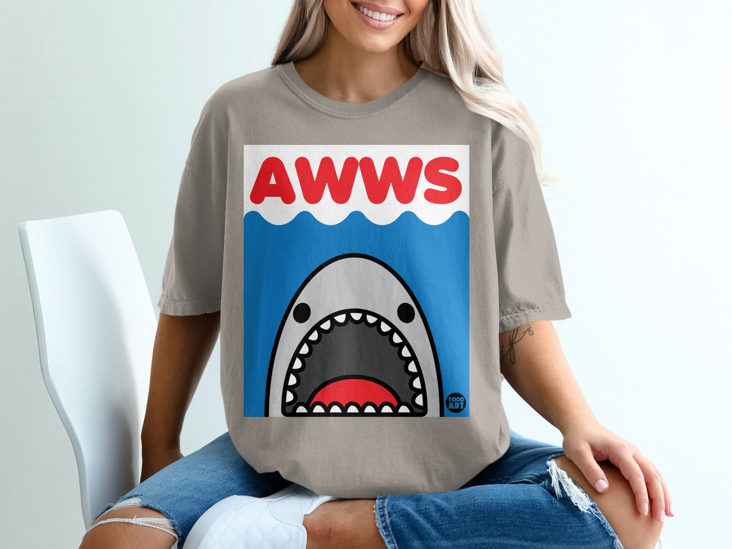 Cartoon shark with open mouth and "AWWS" text on a grey t-shirt.