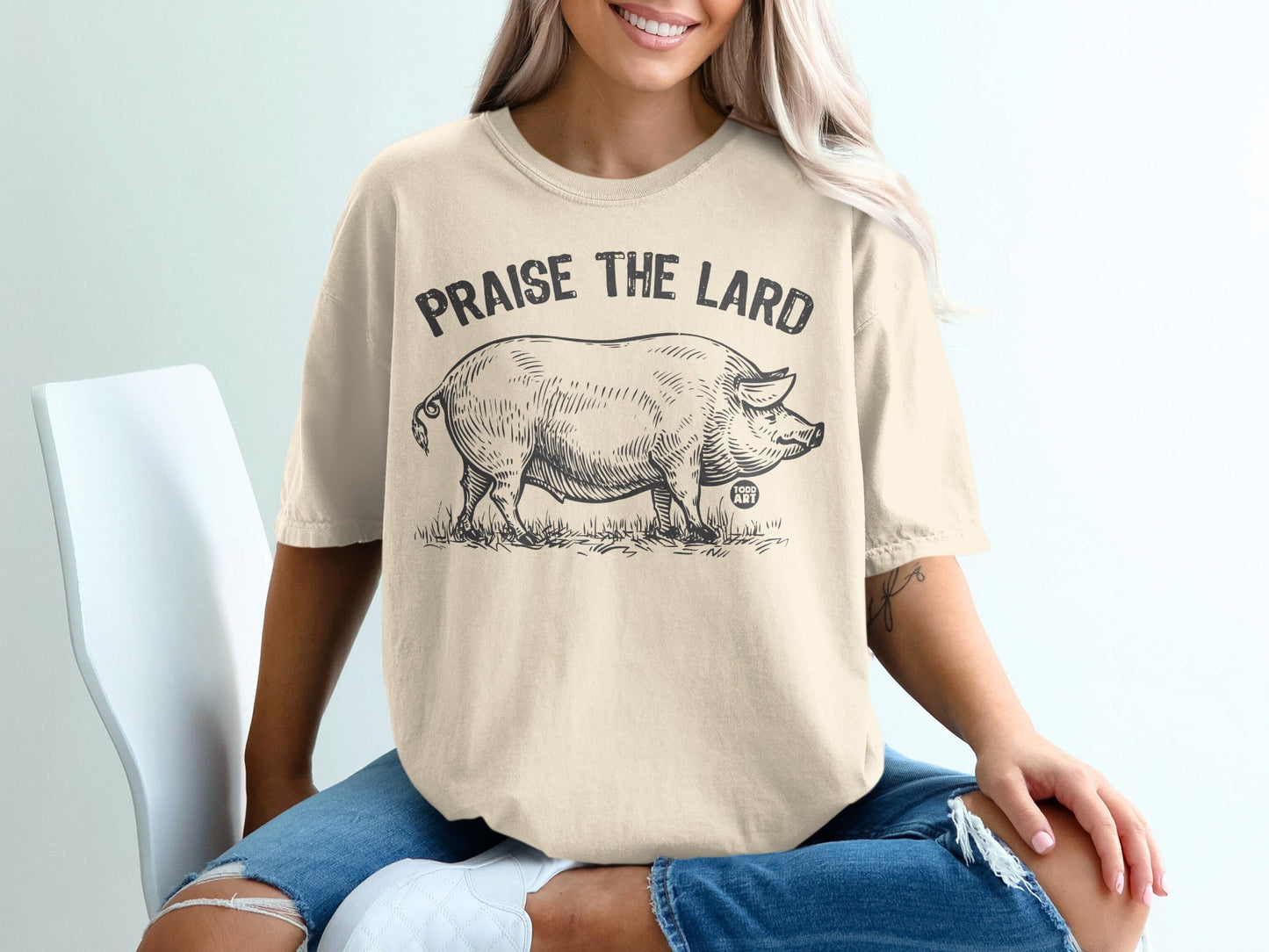 Cream t-shirt with a vintage-style pig illustration and "Praise the Lard" text.