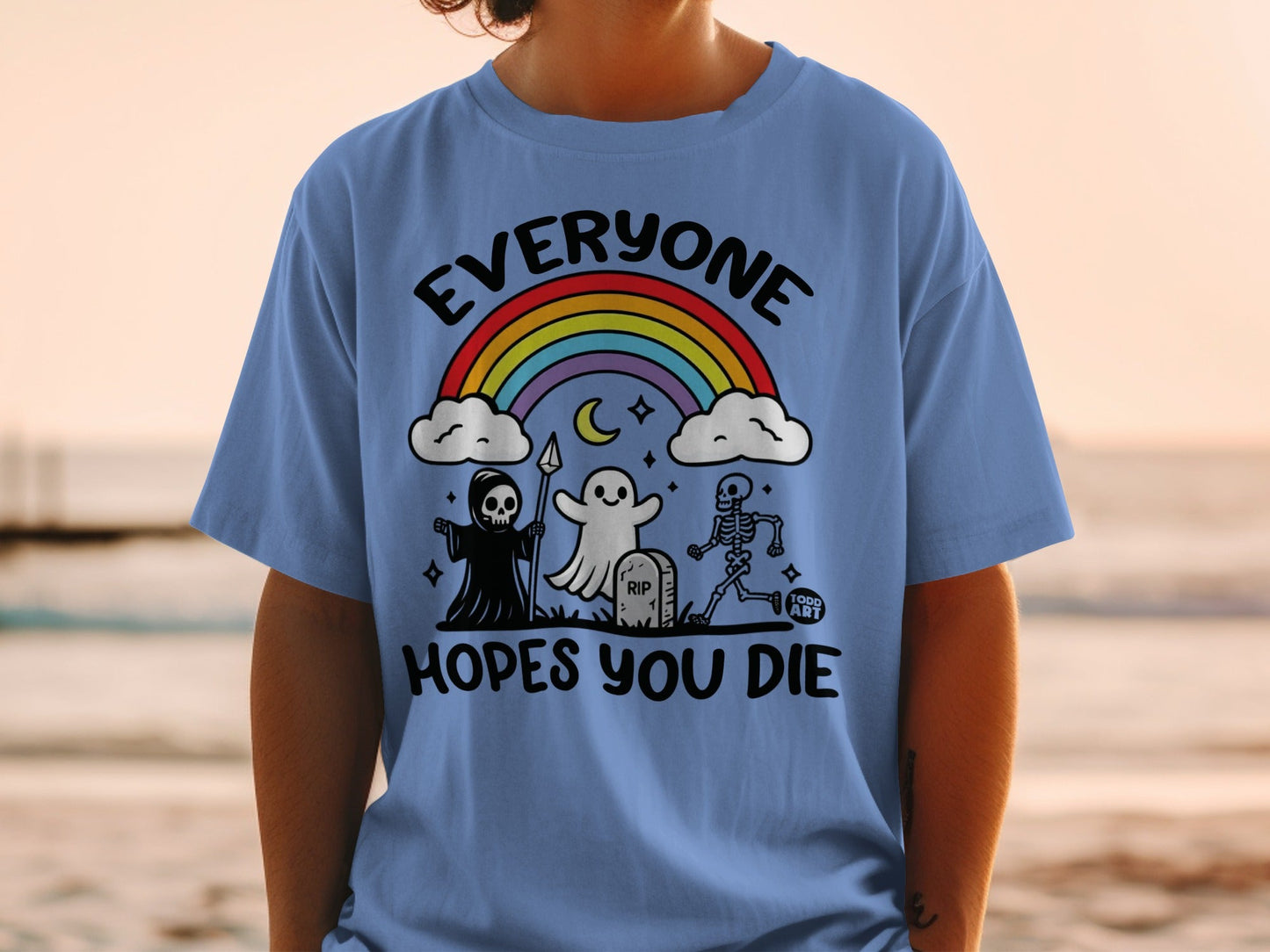 Blue t-shirt with skeleton, grim reaper, ghost, rainbow, and tombstone graphic.