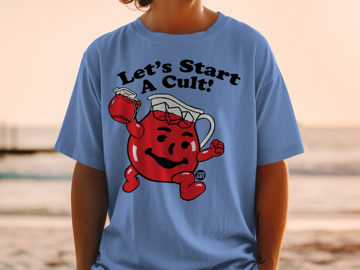 Light blue t-shirt with cartoon character holding a jar, text "Let's Start A Cult!".