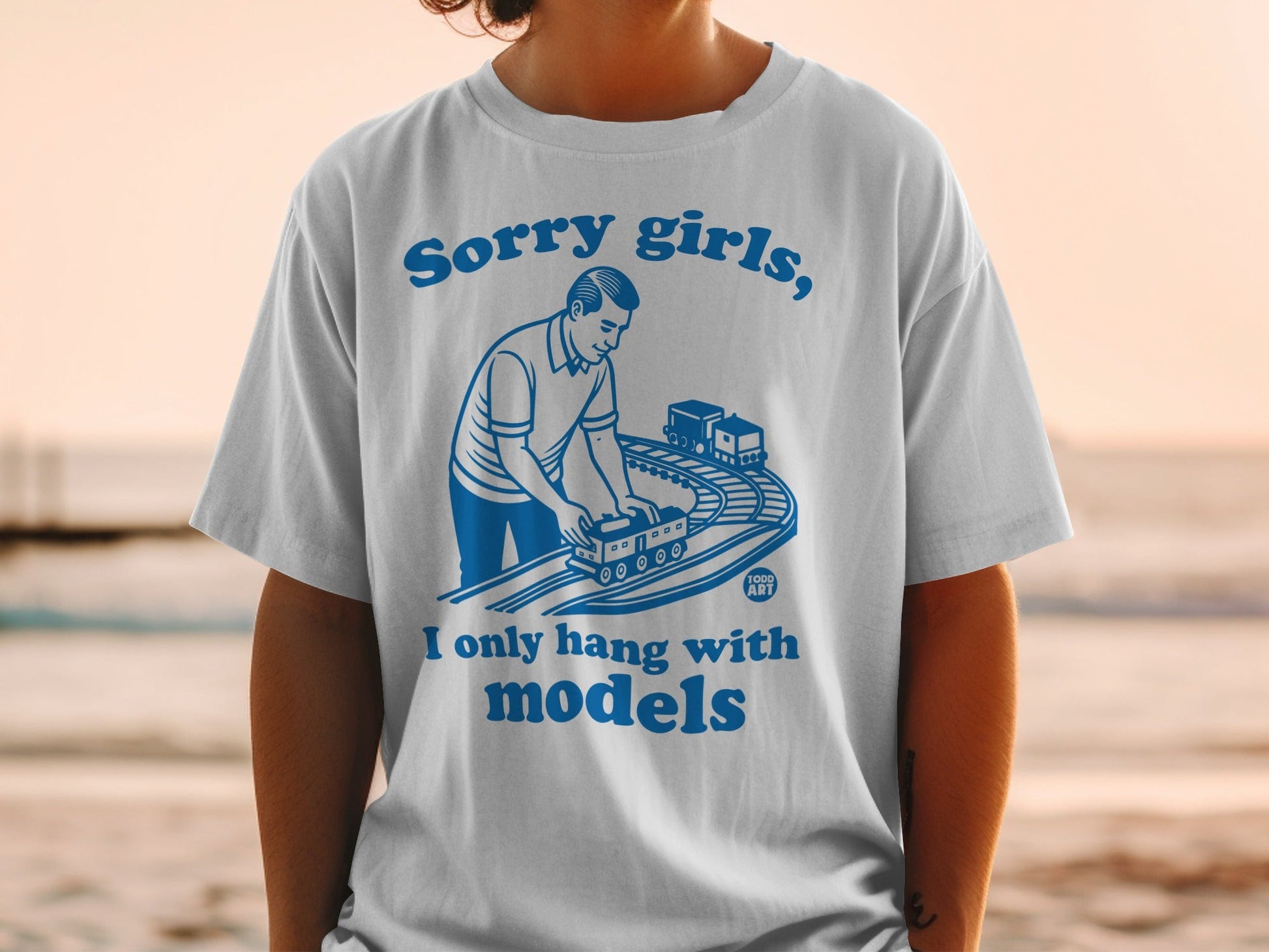 T-shirt with text "Sorry girls, I only hang with models" and a man with toy trains.
