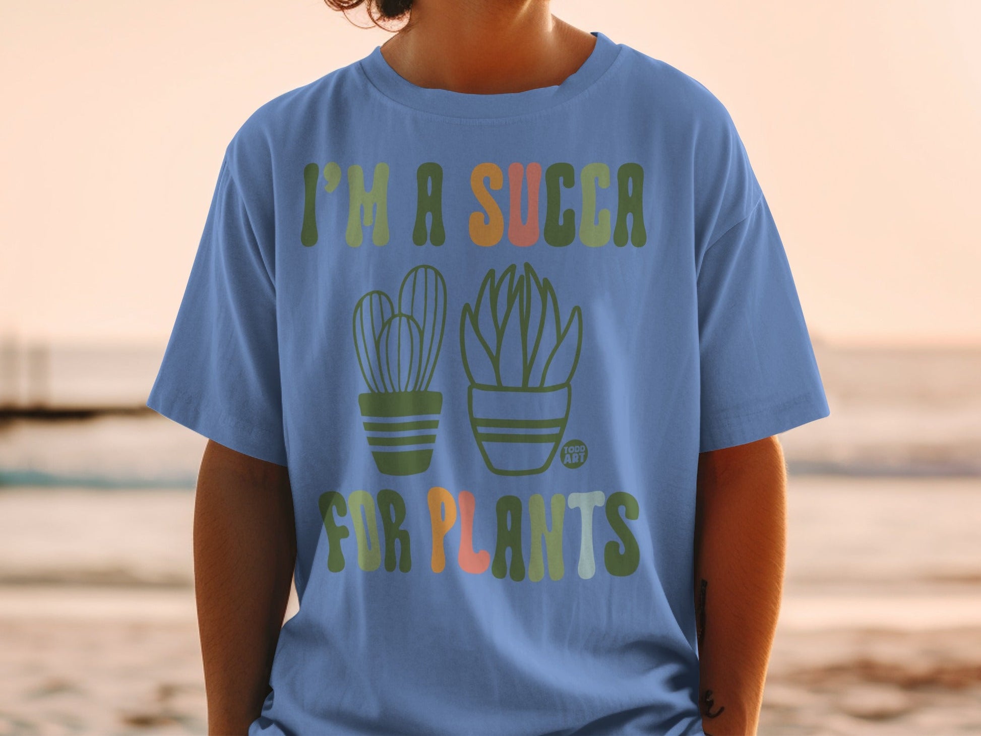 Blue t-shirt with "I'm a succa for plants" and potted succulents graphic.