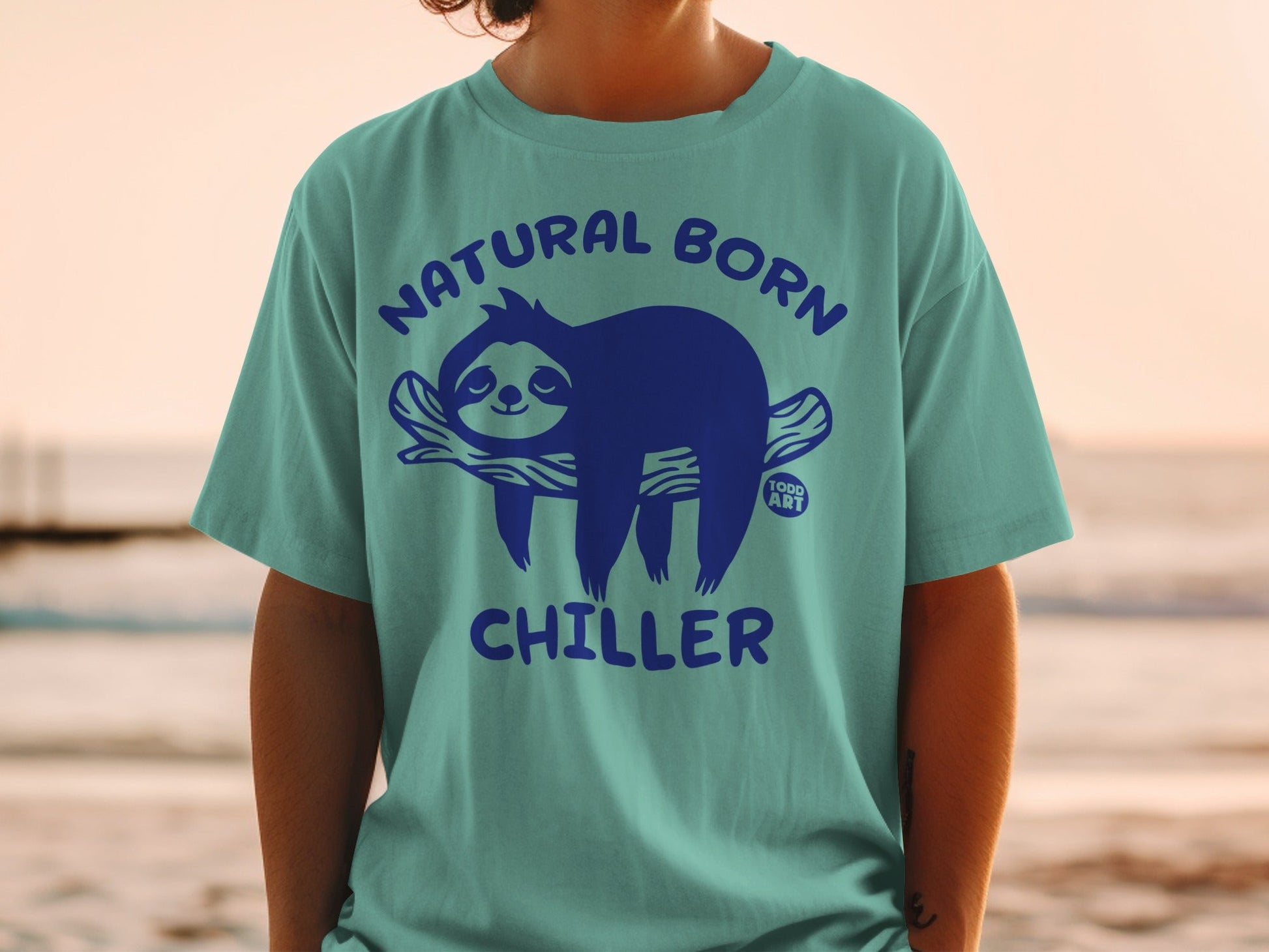 Turquoise t-shirt with a blue sloth graphic and "NATURAL BORN CHILLER" text.
