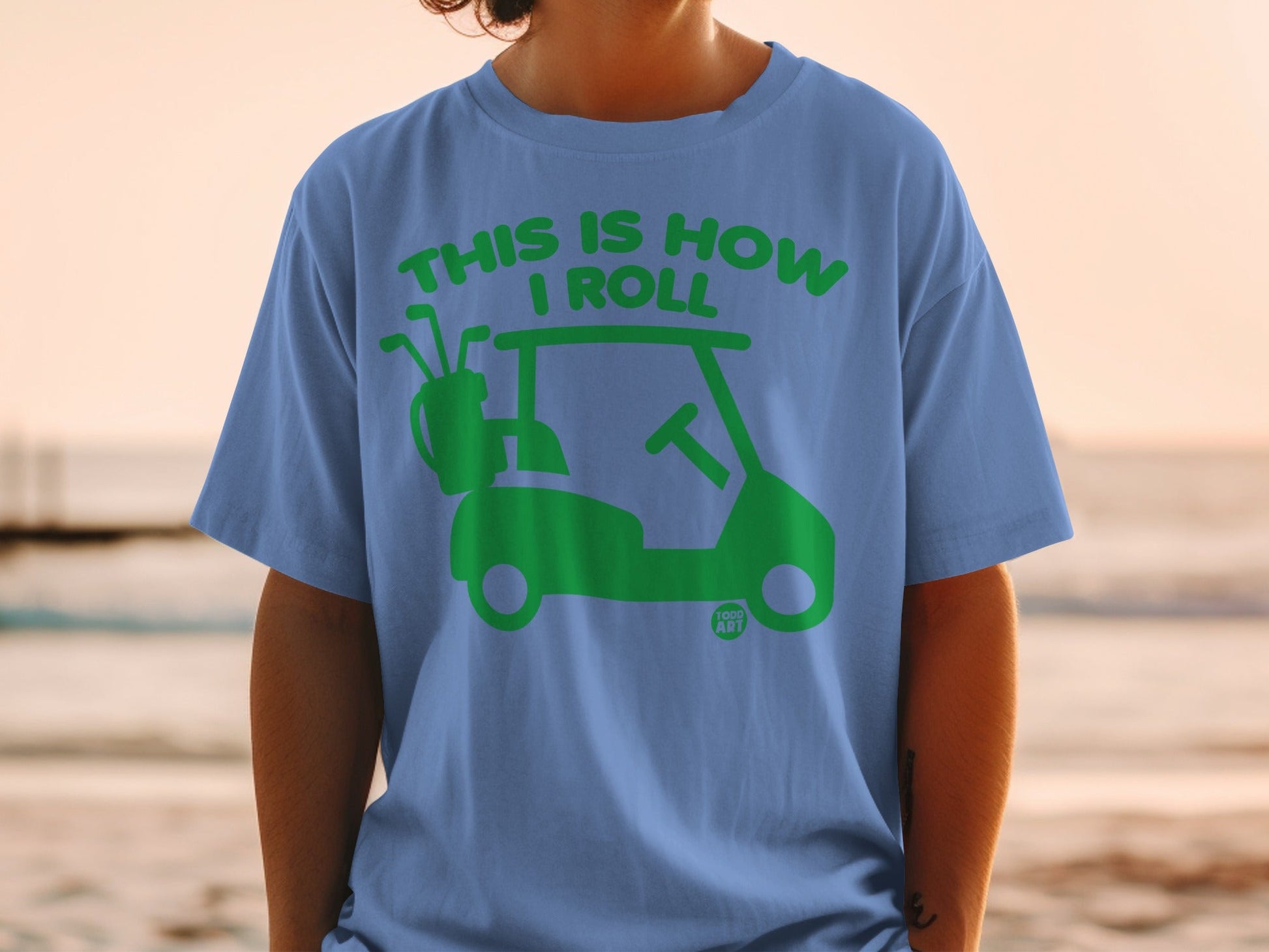 Blue t-shirt with green graphic of a golf cart and text "THIS IS HOW I ROLL".