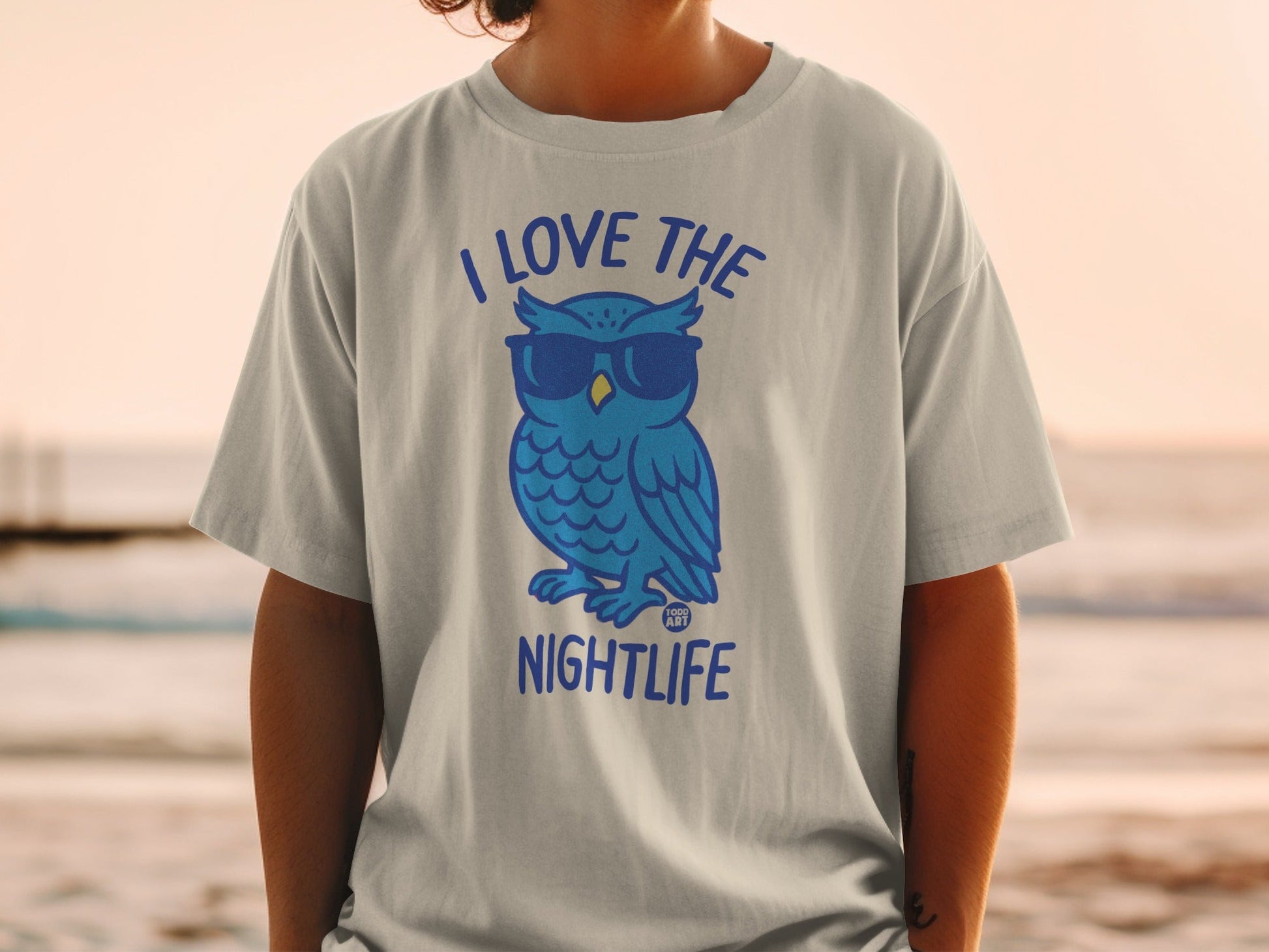 Blue cartoon owl wearing sunglasses and a t-shirt with text.