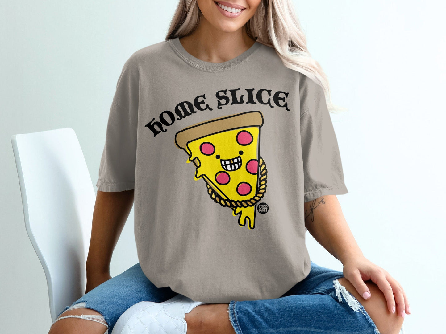 "HOME SLICE" text logo above smiling pizza slice character with gold chain on a taupe t-shirt.
