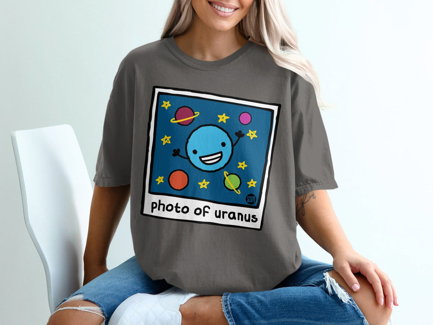Cartoon planet Uranus with stars and moons, on a dark gray t-shirt.
