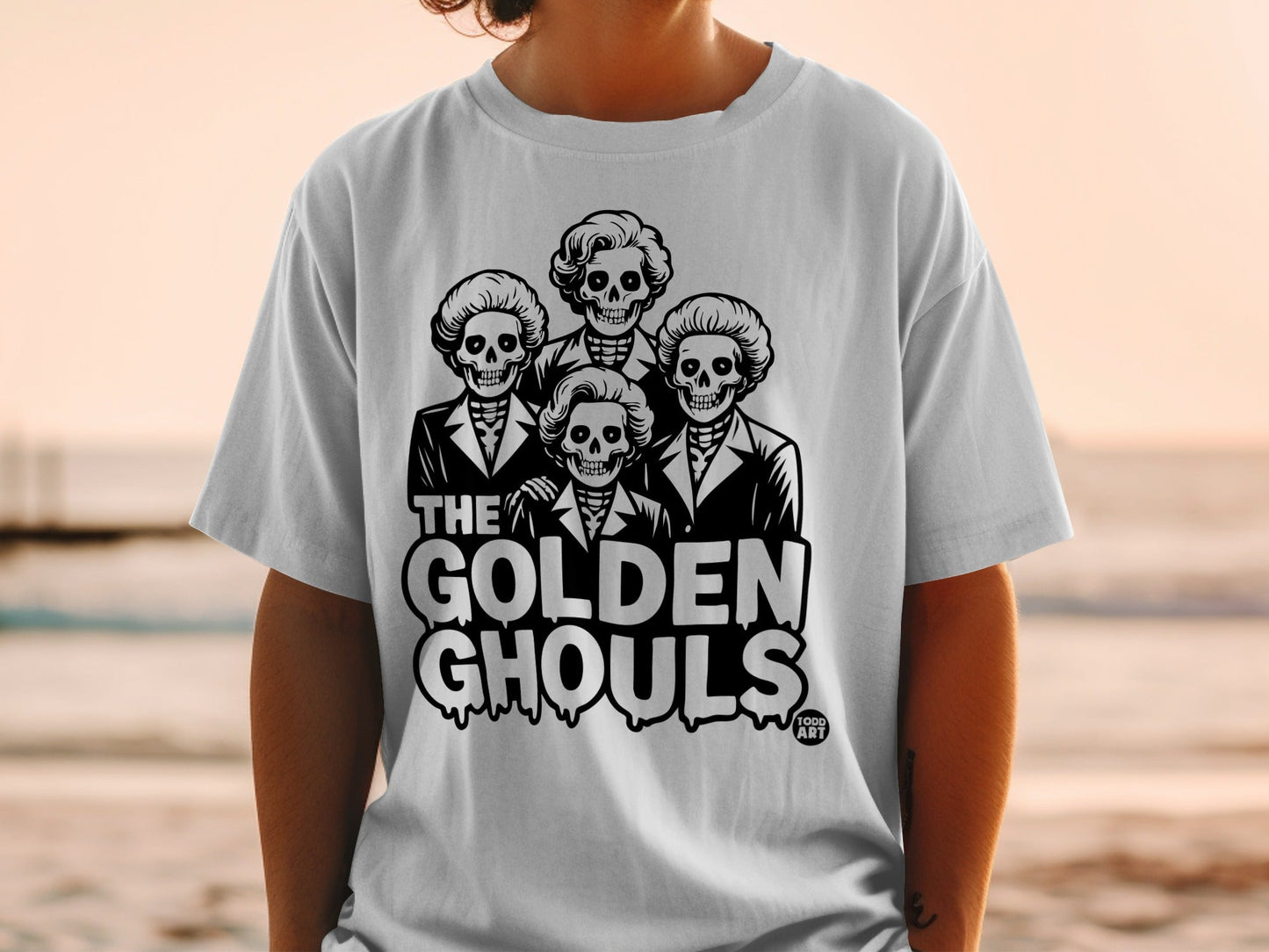 T-shirt with "The Golden Ghouls" text and four skeleton heads wearing suits.