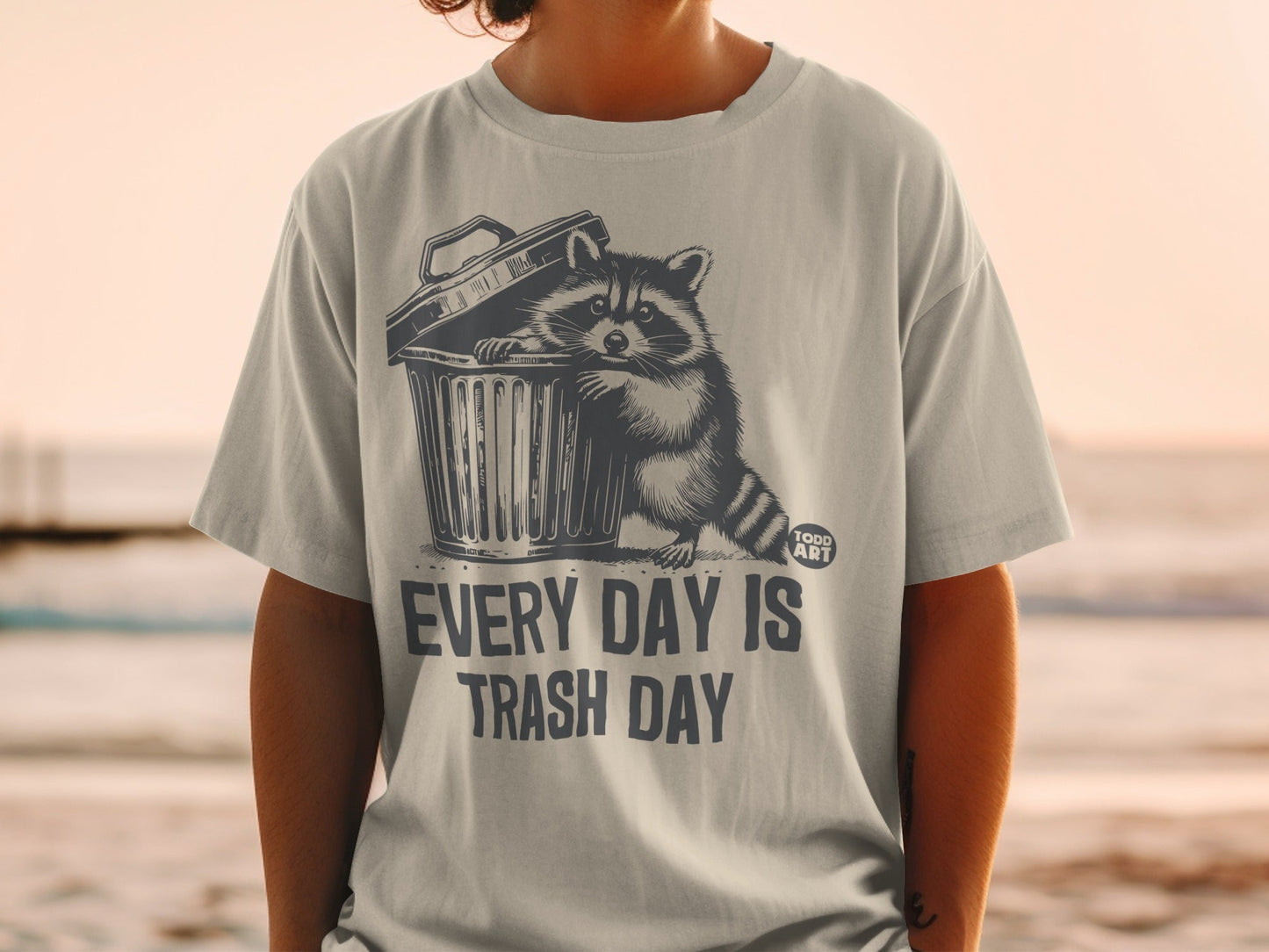 Graphic t-shirt with raccoon in trash can and text "Every day is trash day."