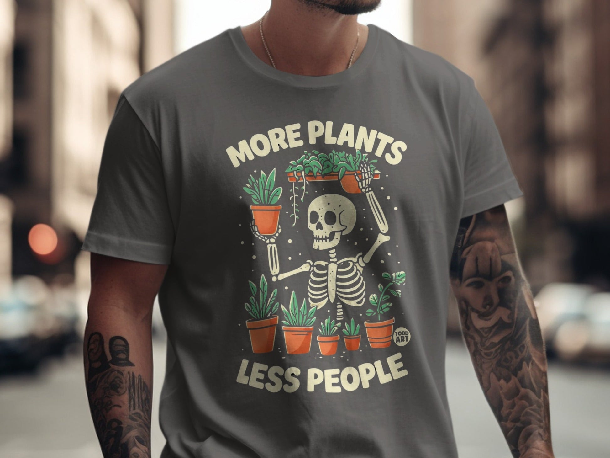 Gray t-shirt with skeleton holding potted plants and text "More Plants Less People".