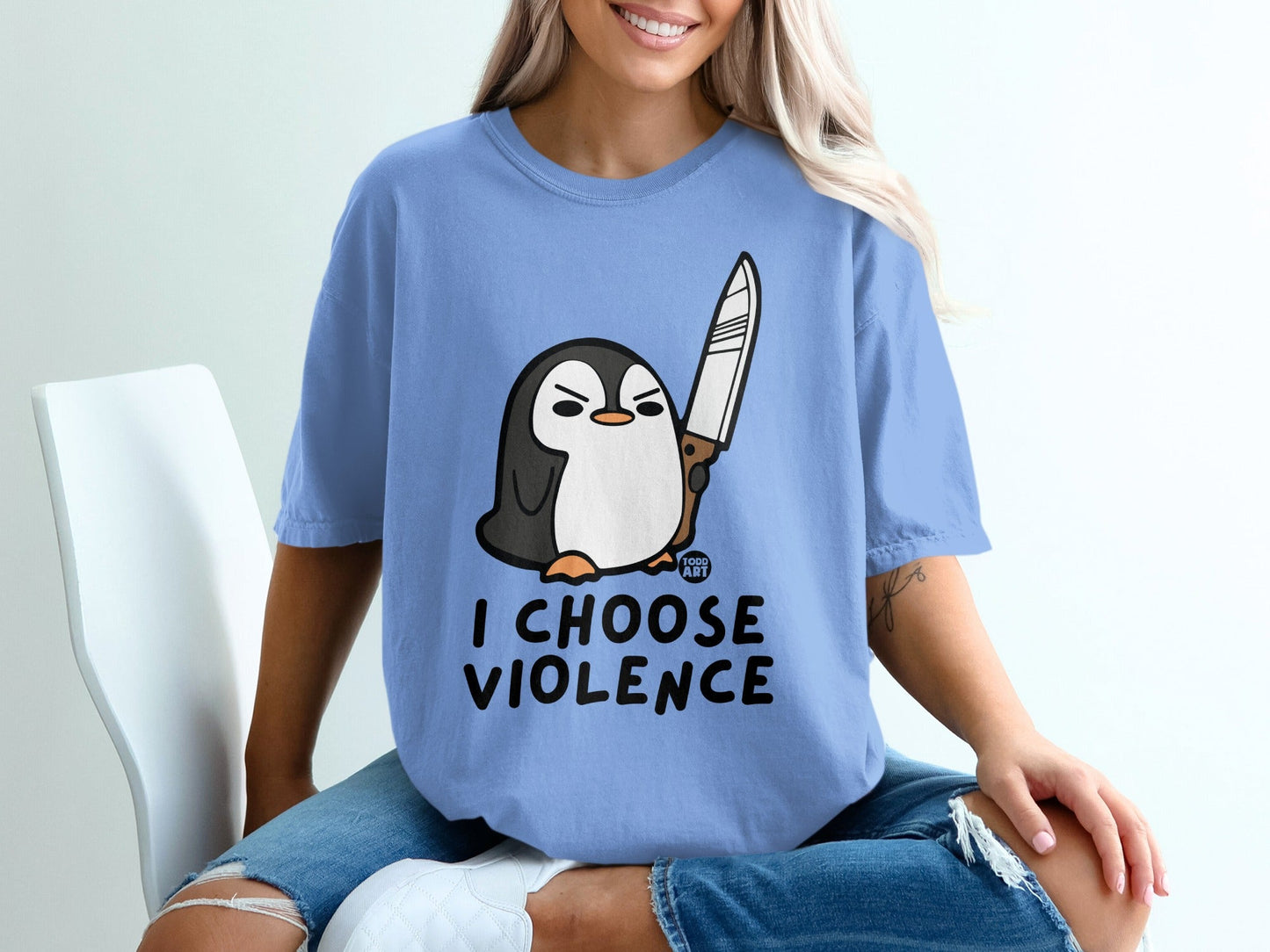 Penguin holding a knife with text "I CHOOSE VIOLENCE" on a blue t-shirt.