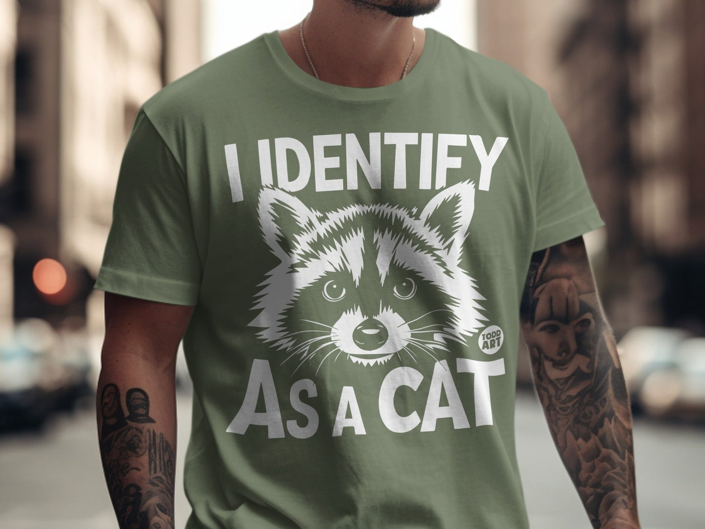 Green t-shirt with "I IDENTIFY AS A CAT" and raccoon graphic.