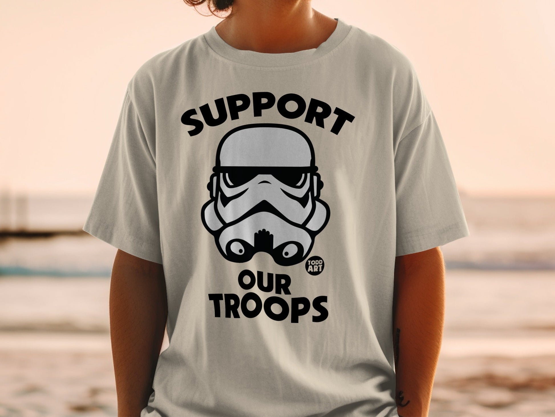 Stormtrooper helmet graphic on a t-shirt with "SUPPORT OUR TROOPS" text.
