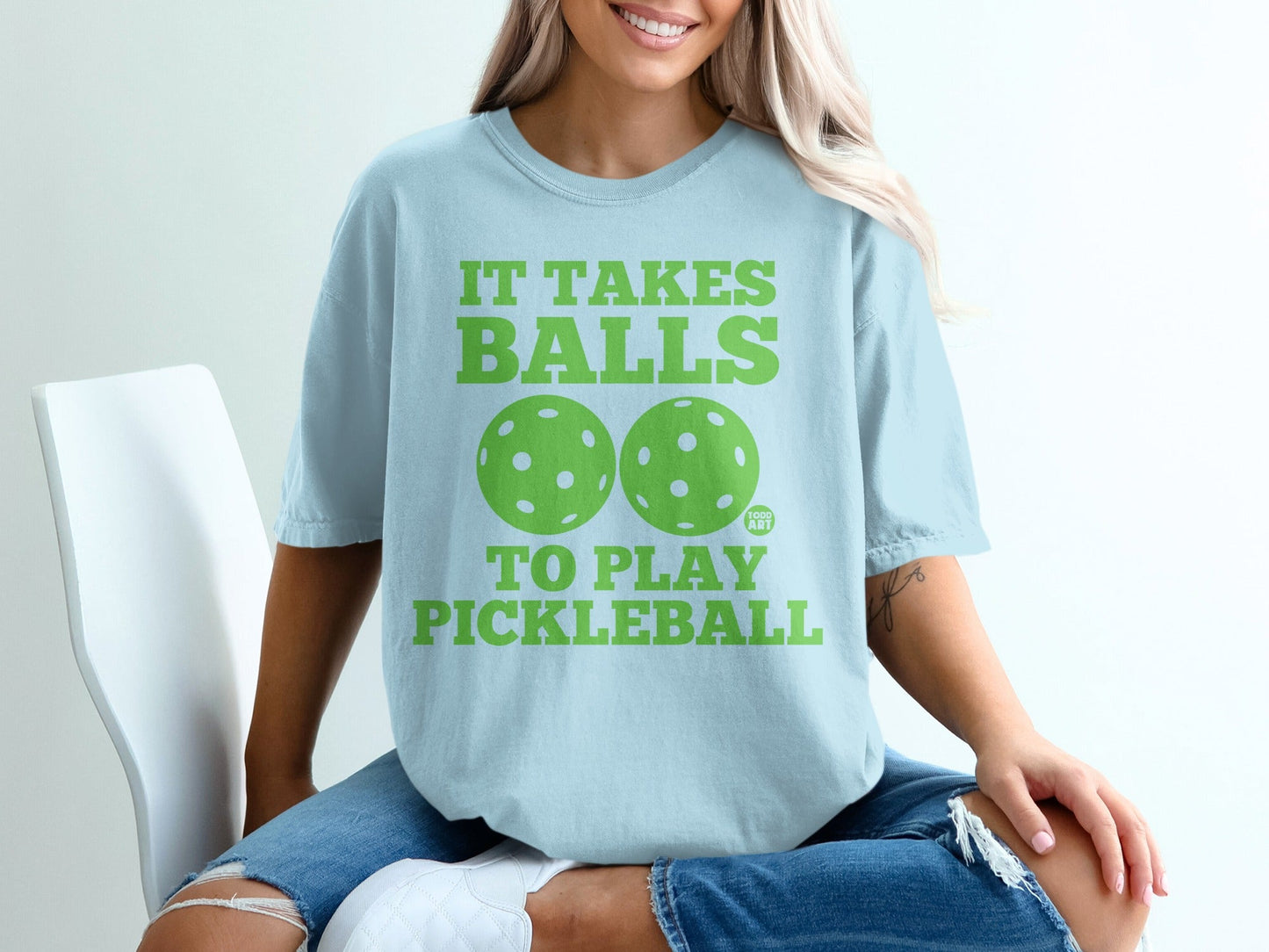 Light blue t-shirt with "It Takes Balls To Play Pickleball" and two pickleball graphics.