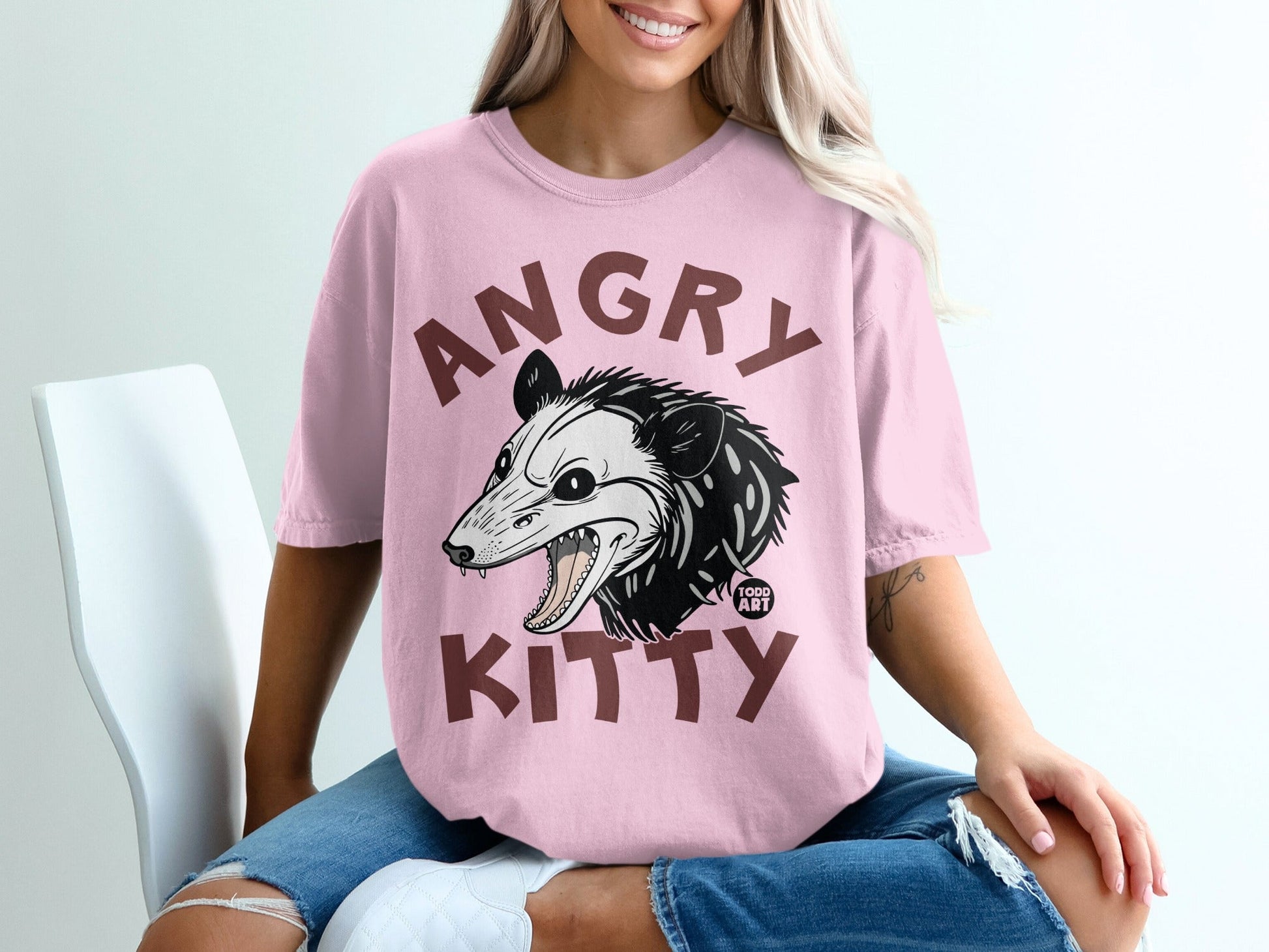 Pink t-shirt with distressed graphic of an angry opossum and "ANGRY KITTY" text.