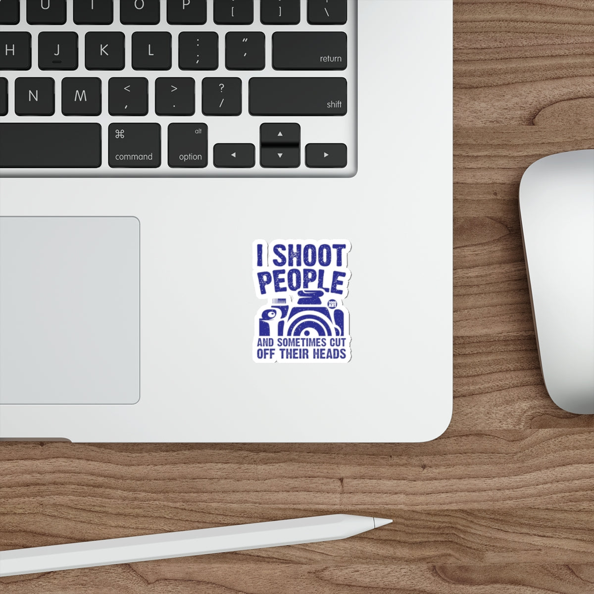 Blue sticker on laptop with text "I shoot people and sometimes cut off their heads"