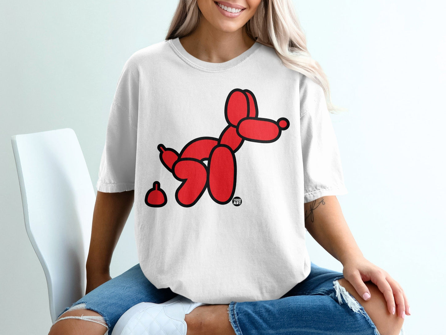 Red balloon dog with small brown poop on white t-shirt.
