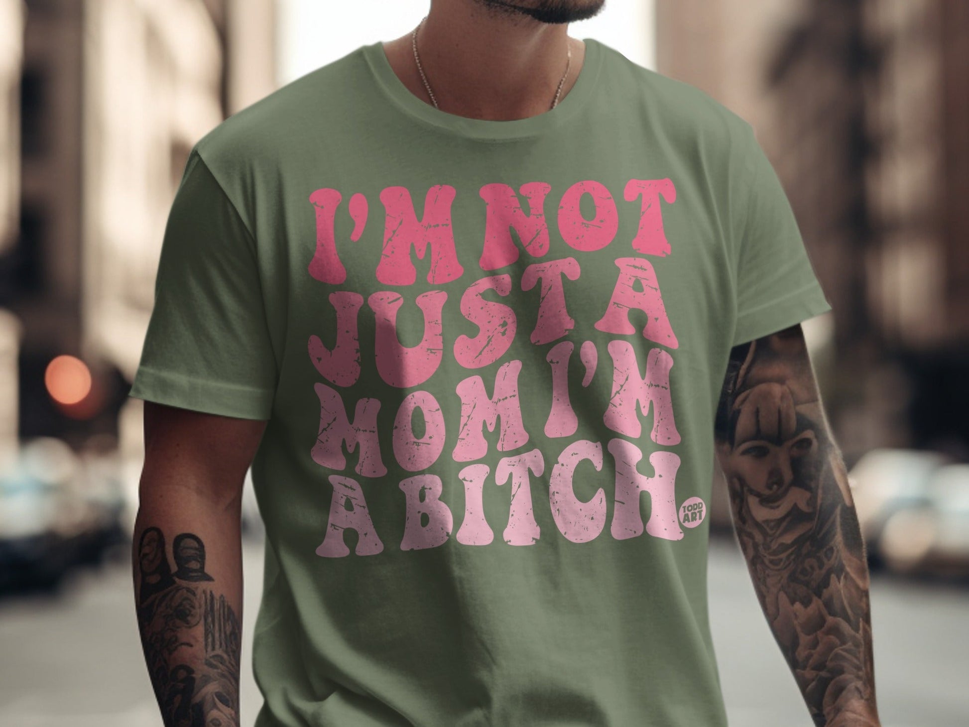 Green t-shirt with pink text reading "I'm not just a mom, I'm a bitch".