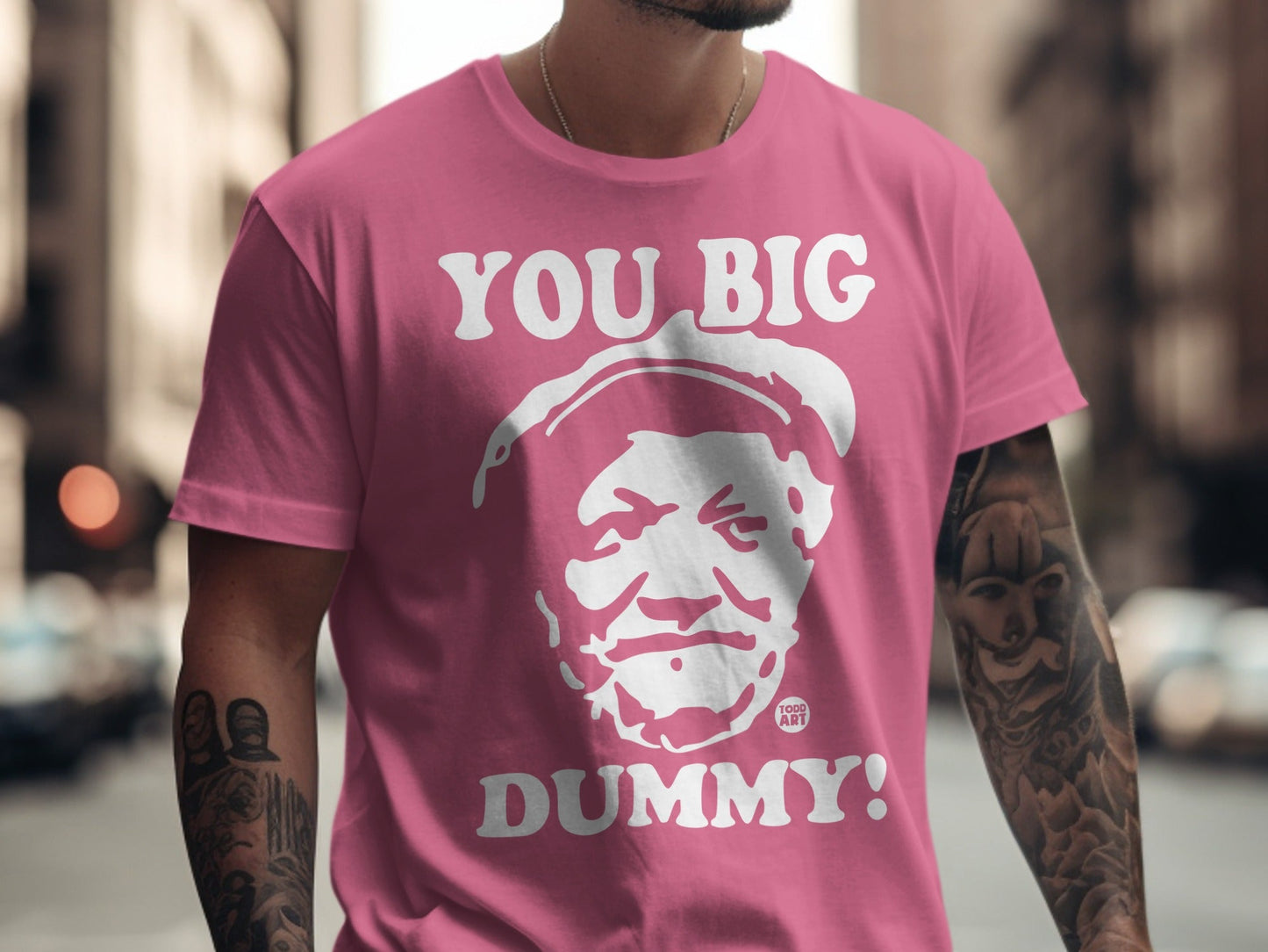 Pink t-shirt with white text "YOU BIG DUMMY!" and a caricature face.