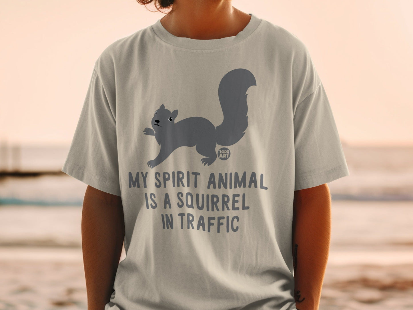 Light grey t-shirt with a charcoal grey squirrel and text that reads "MY SPIRIT ANIMAL IS A SQUIRREL IN TRAFFIC".