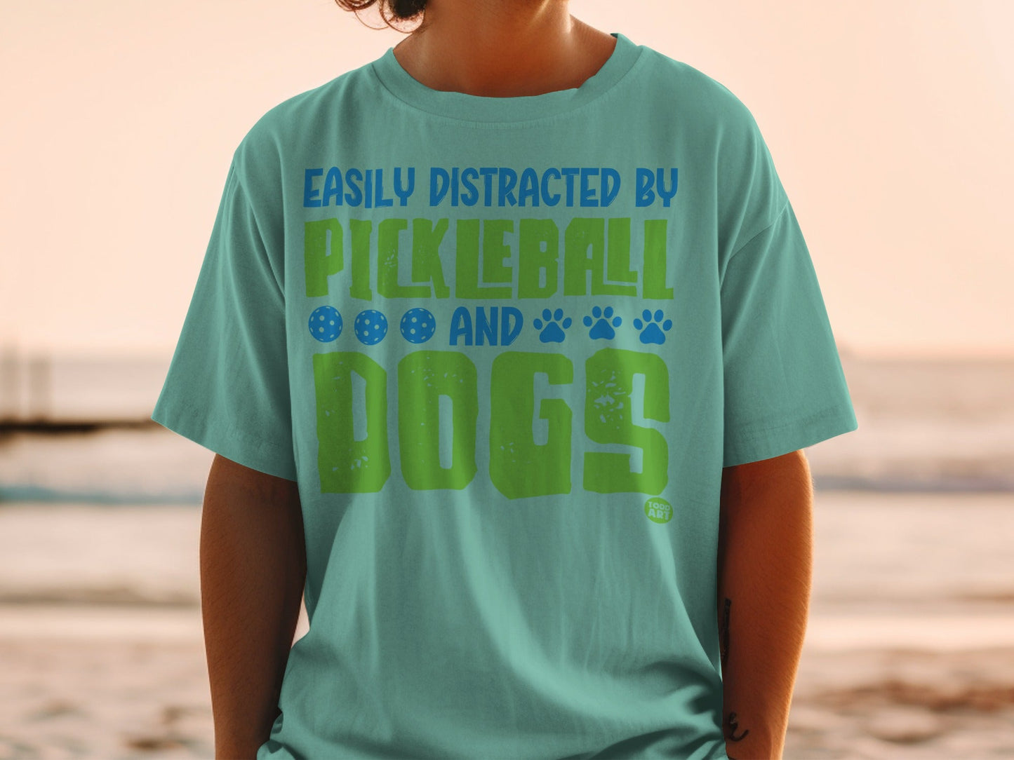 Teal t-shirt with "Easily Distracted by Pickleball and Dogs" text and graphics.